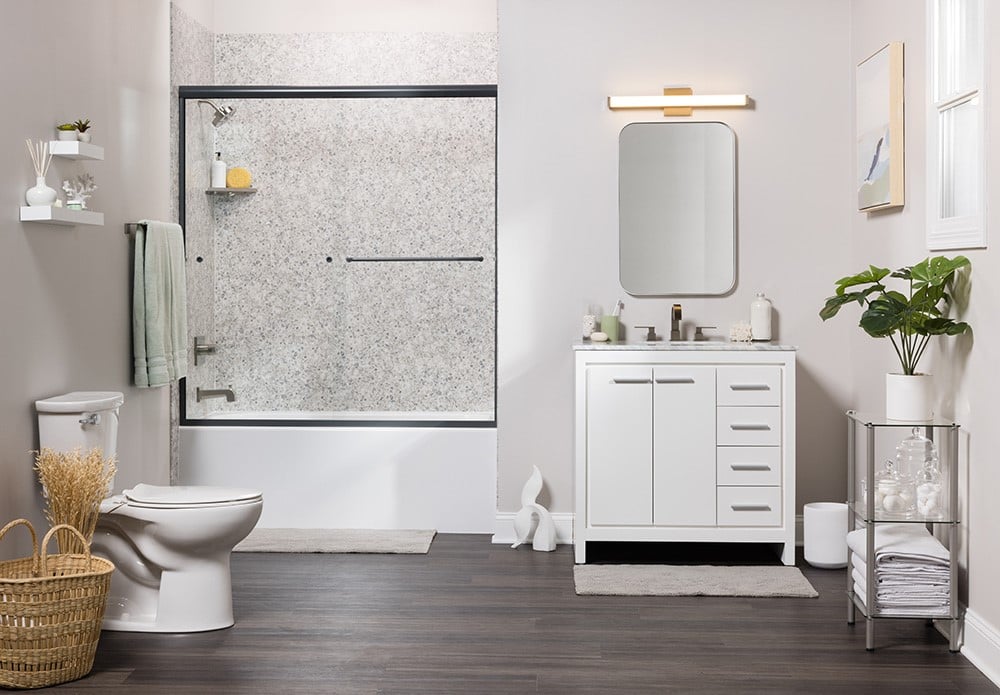 A clean bathroom featuring a white vanity, a toilet, and a shower, all arranged in a modern layout.