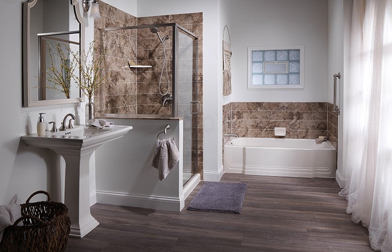 A bathroom featuring a shower, sink, and toilet, designed for functional and practical use.