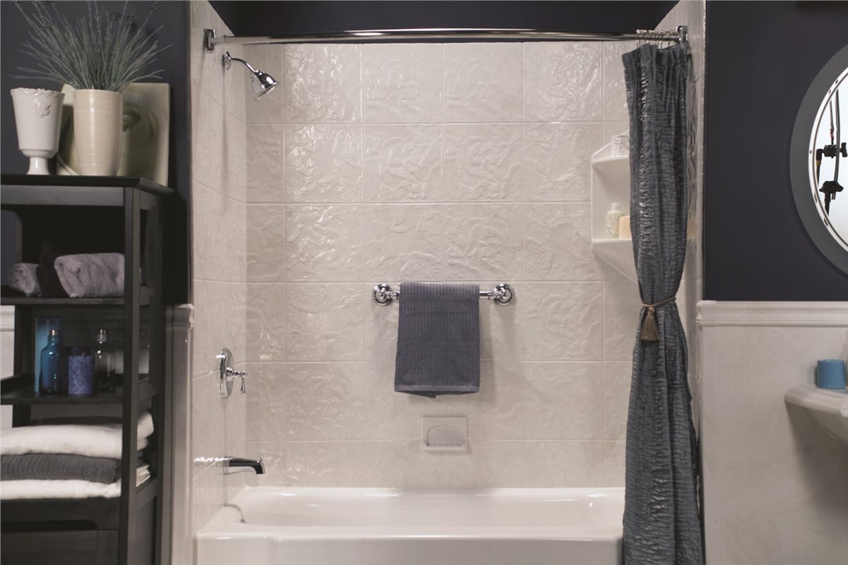 Bathroom featuring a shower, sink, and toilet, with neutral-colored tiles and modern fixtures.