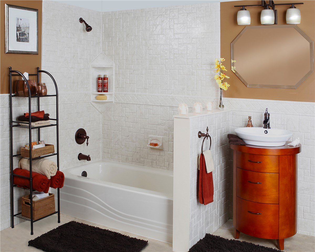 A modern bathroom with white tiled bathtub, bronze fixtures, octagonal mirror, and decorative shelving unit.