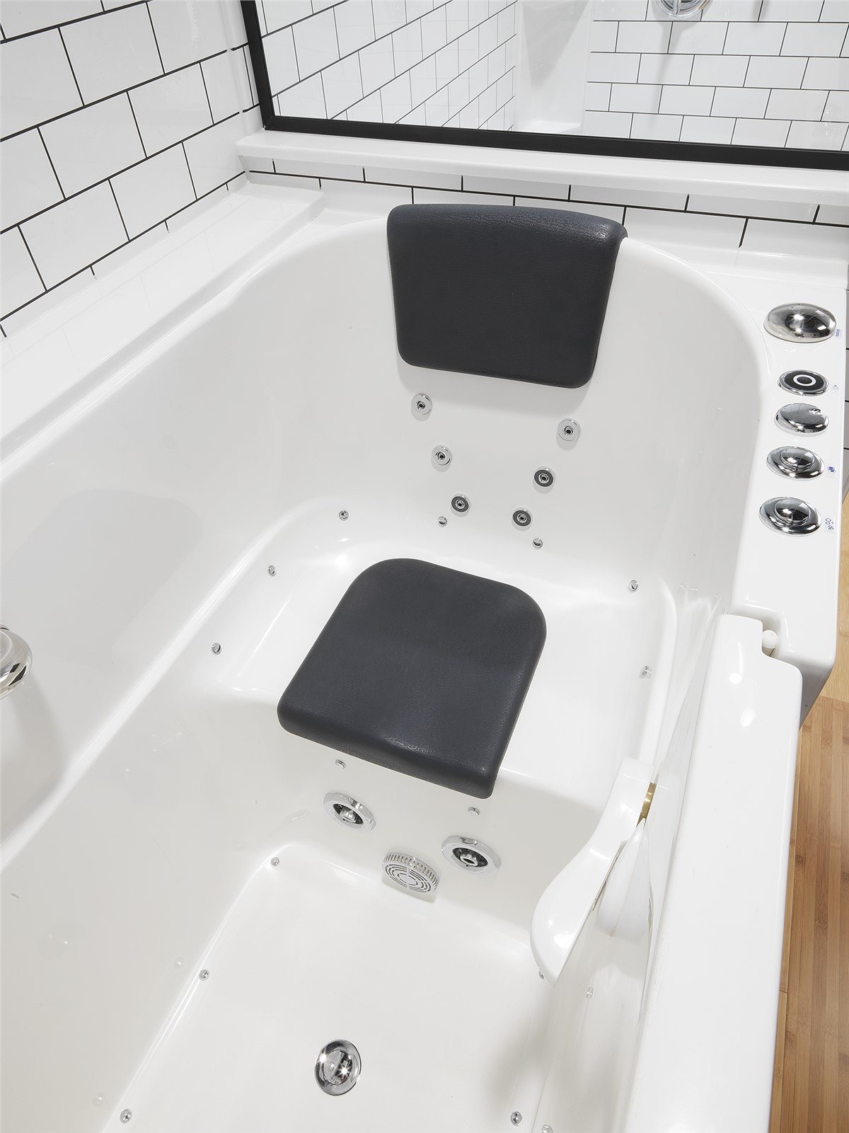 A bath tub featuring a built-in seat and an overhead shower head for accessible bathing.
