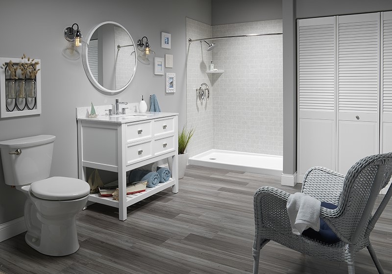 A clean bathroom featuring a white vanity, a toilet, and a shower, all arranged in a modern layout.