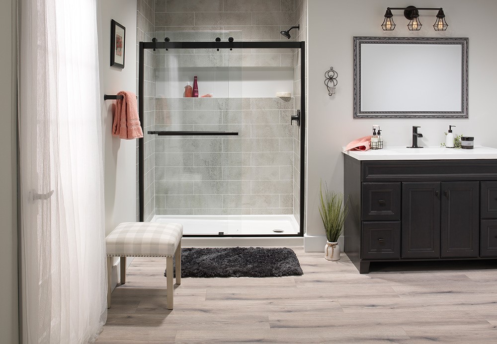 A clean bathroom featuring a shower, sink, and toilet, with neutral-colored tiles and modern fixtures