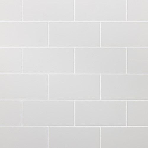 A white wall featuring a subtle white tile pattern, creating a clean and minimalist aesthetic