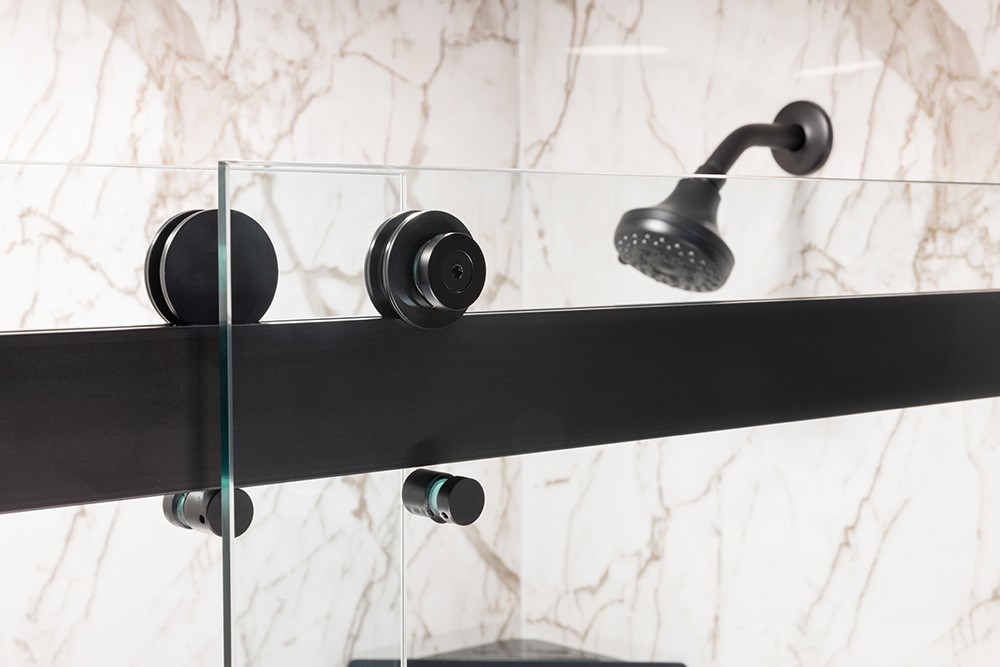 A modern shower featuring a glass door with sleek black handles