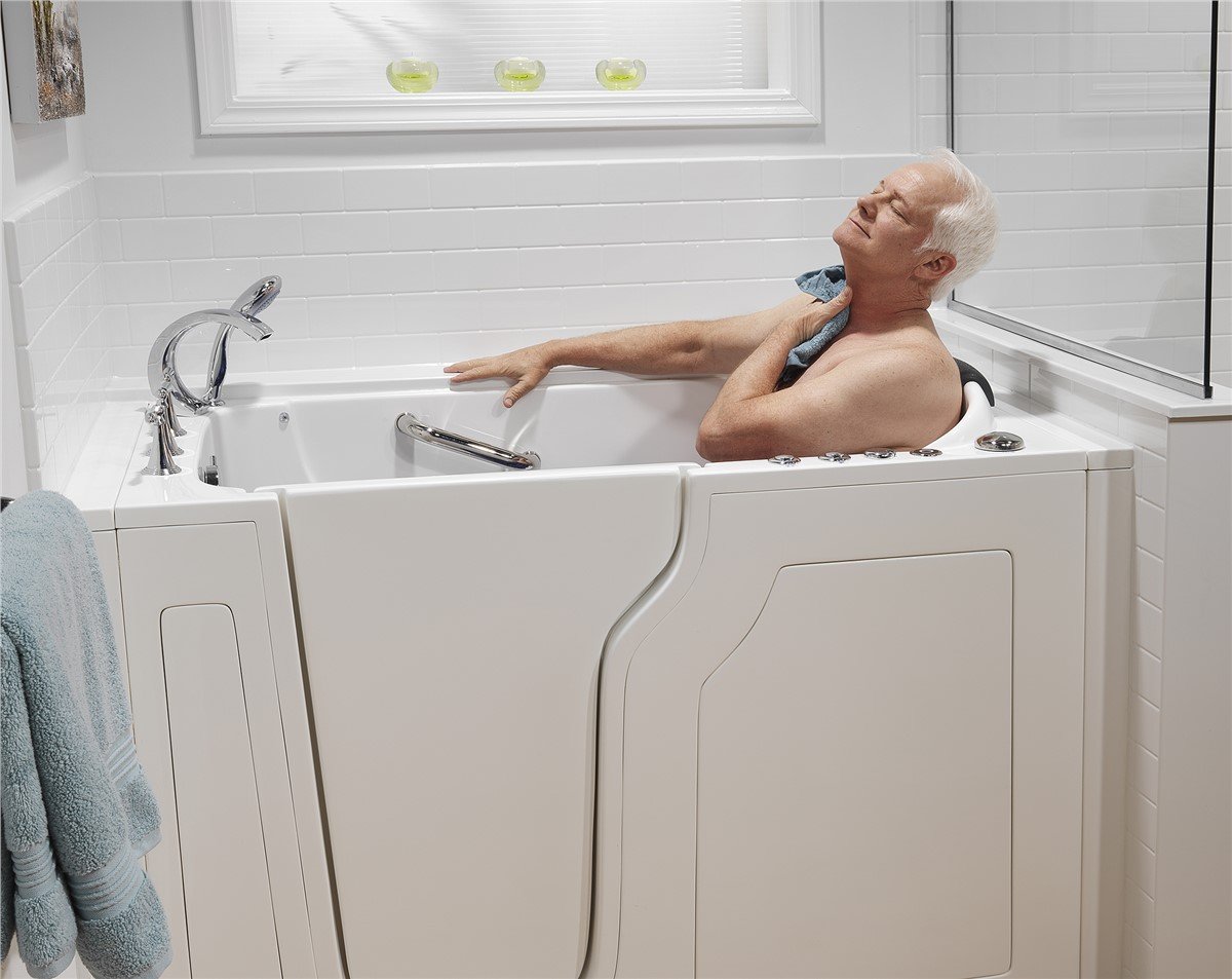 A man relaxes in a bathtub, tilting his head back with eyes closed, enjoying a moment of tranquility.