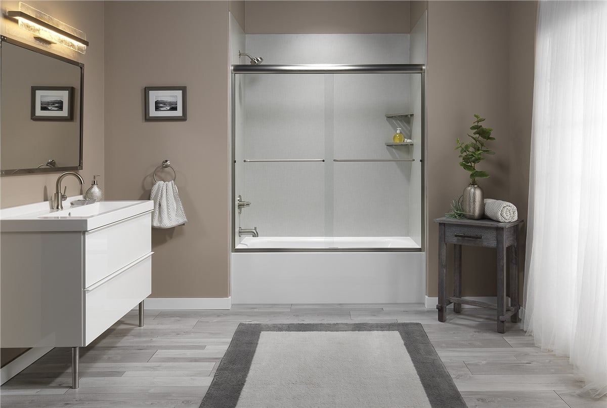 Bathroom featuring a shower, sink, and toilet, with neutral-colored tiles and modern fixtures.